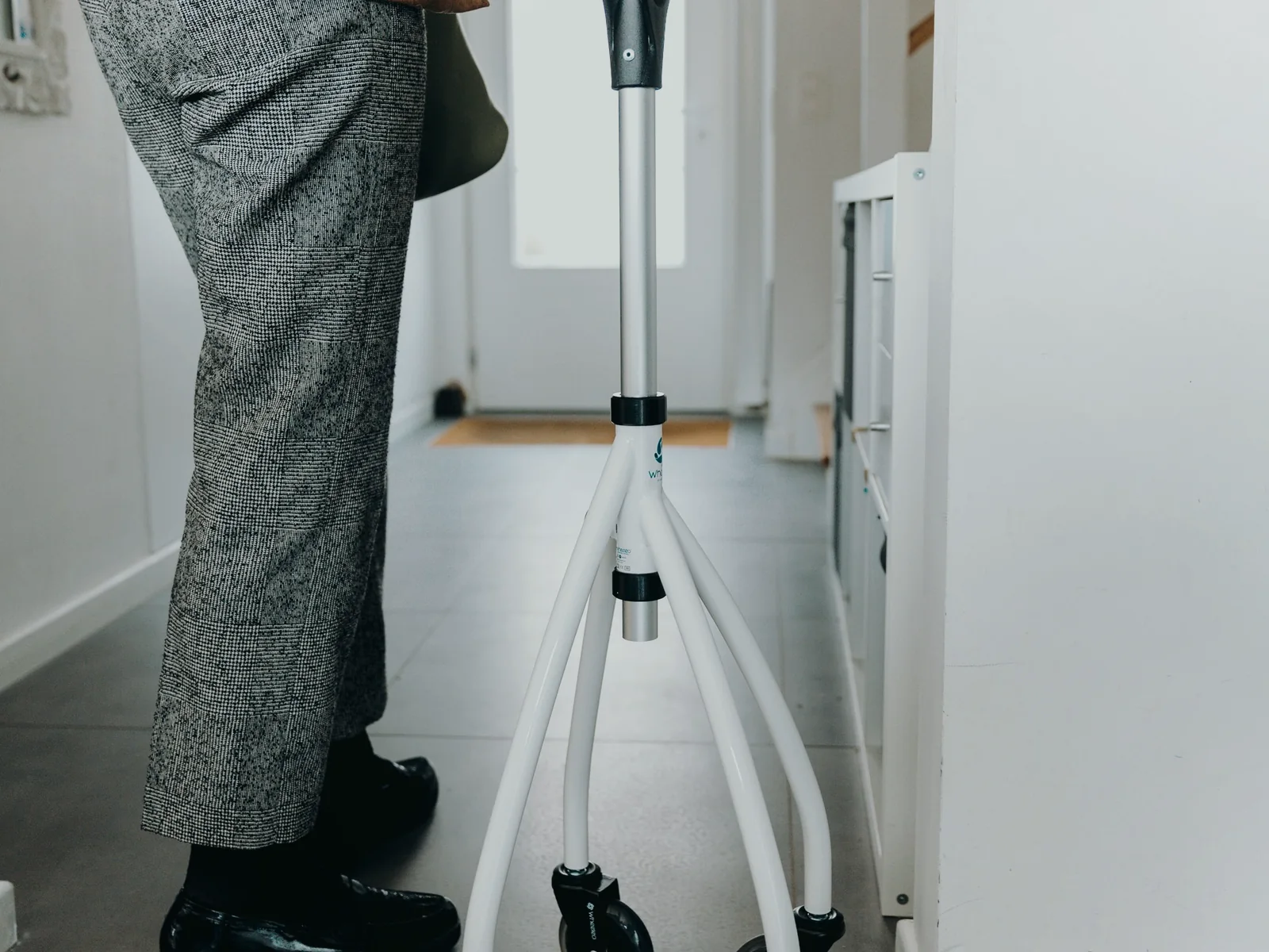 Adult using a rollator in a bright, uncluttered home