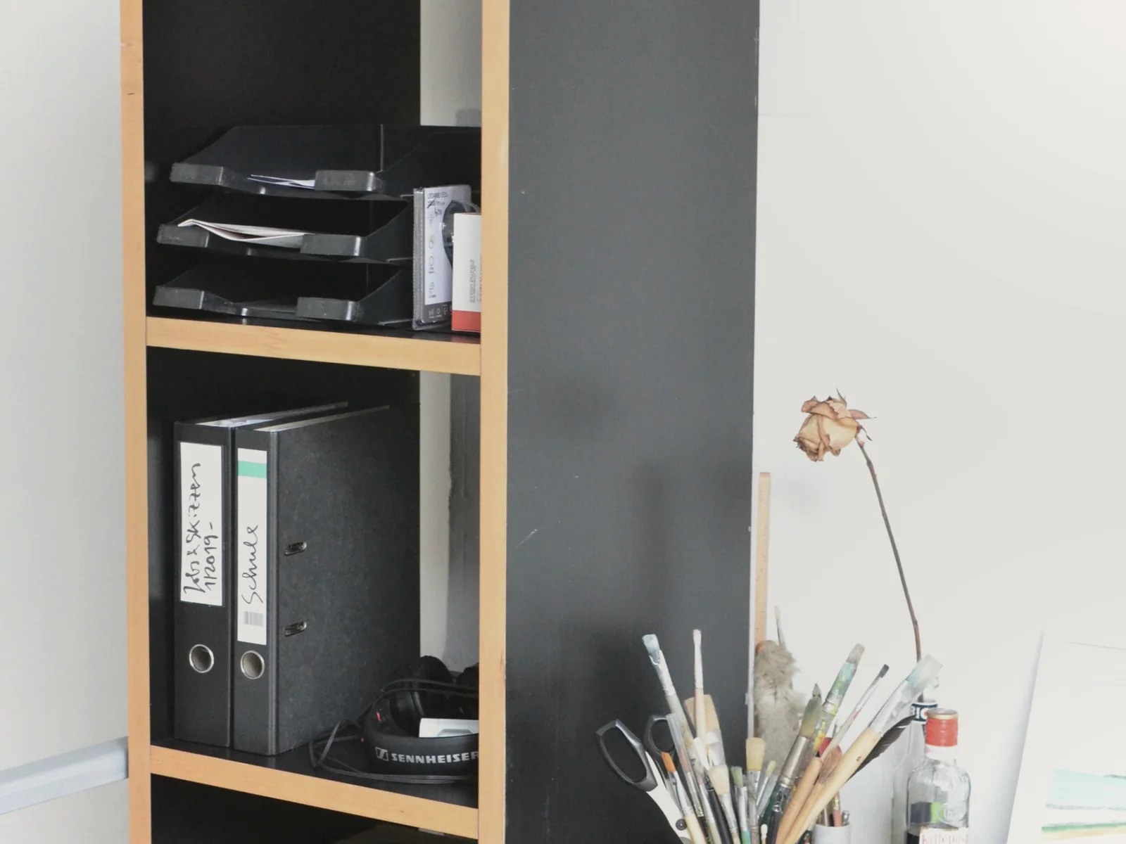 Binders and document trays organized on an open shelf
