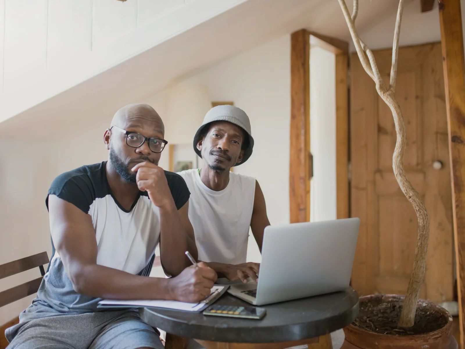 Two adults planning together with a laptop and notebook at home