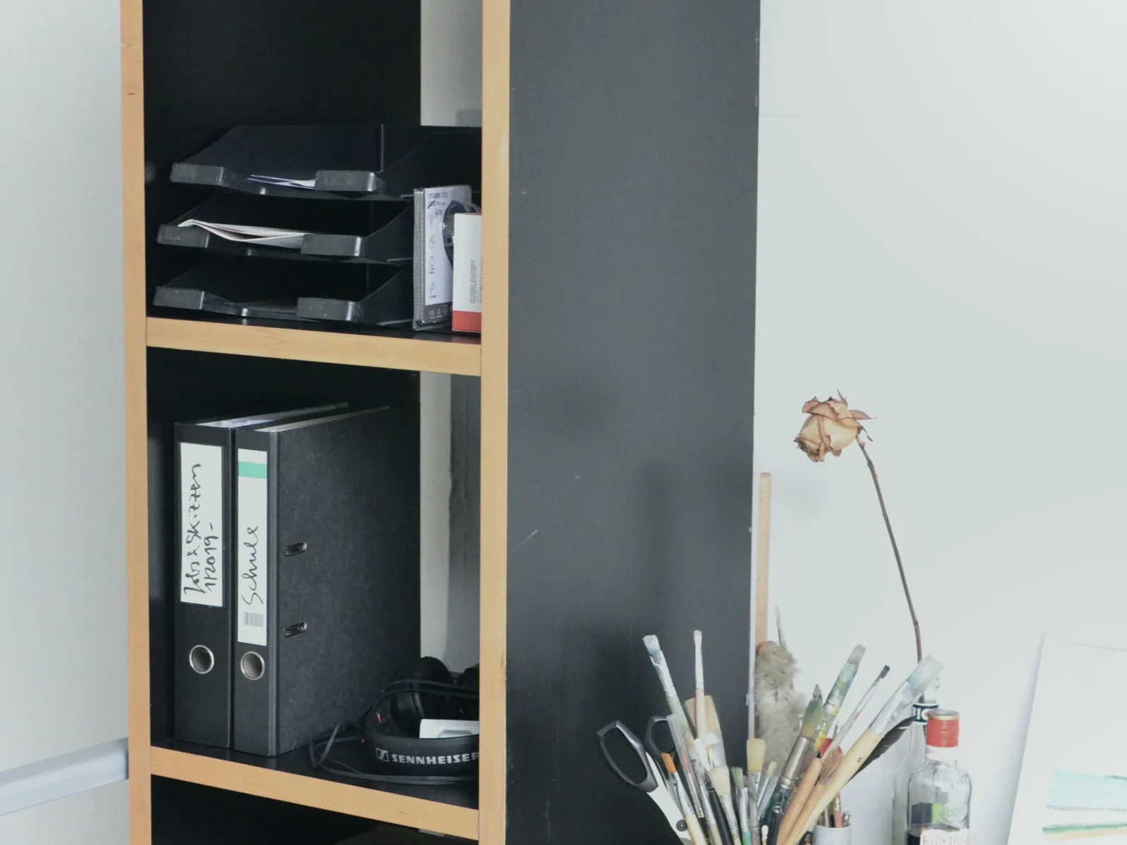 Binders and organizing trays arranged on an open shelf