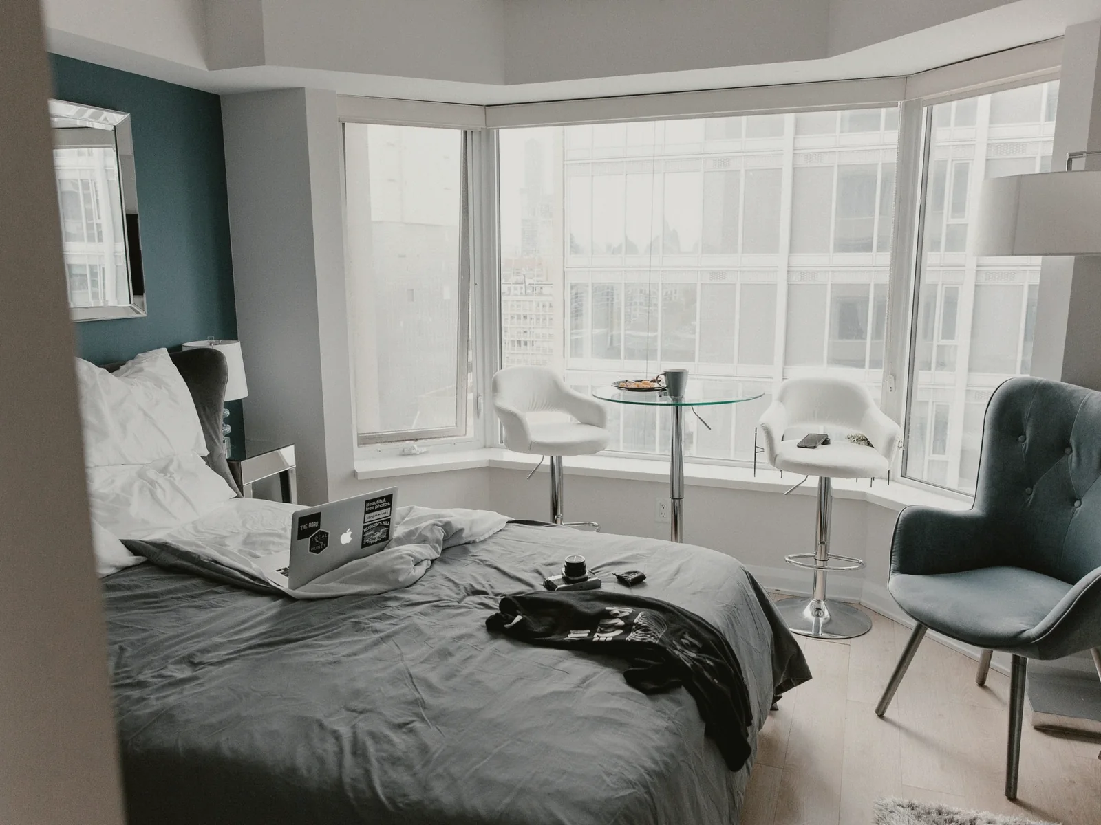 Bright hotel room with a laptop and personal items on the bed