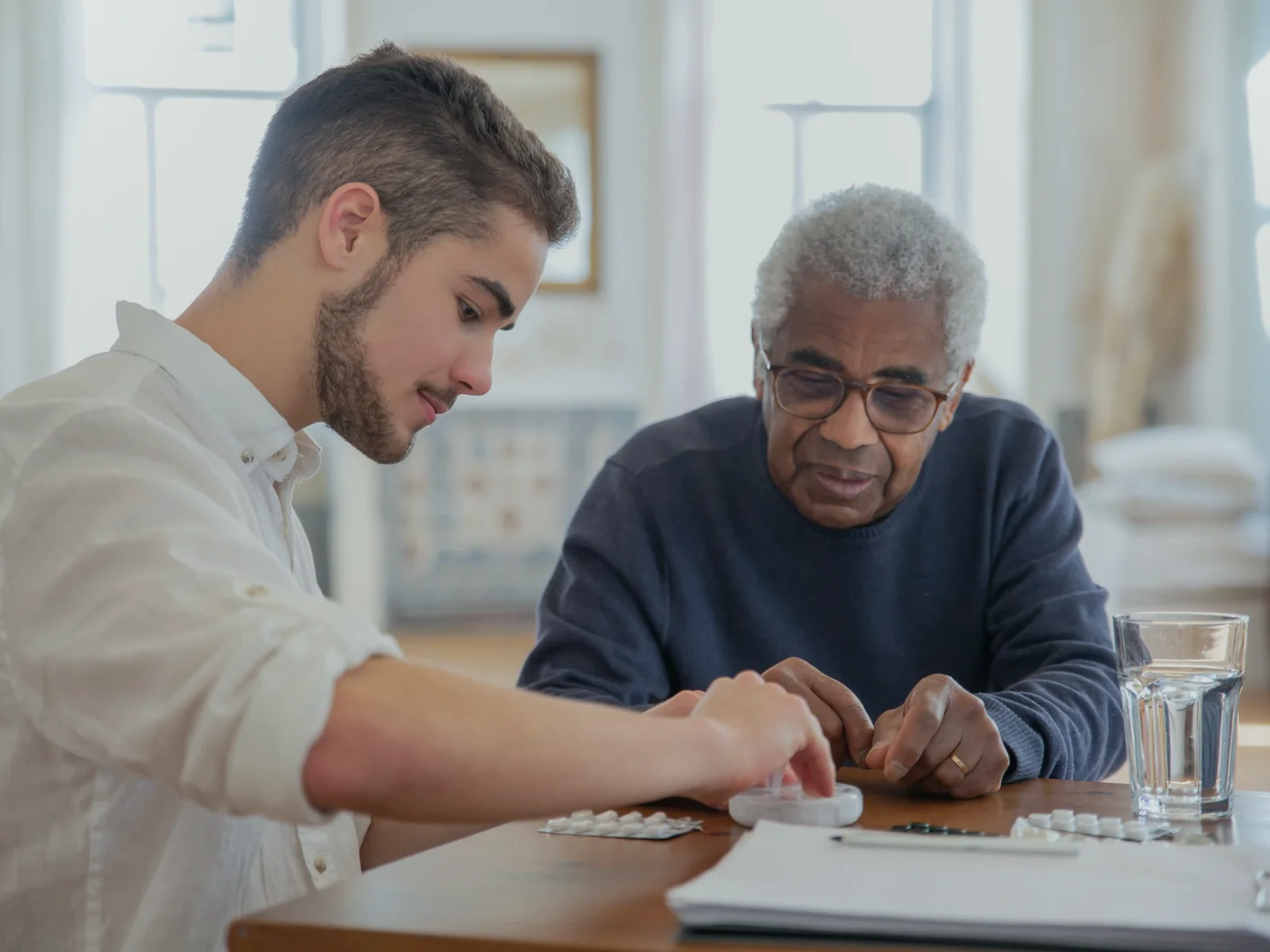 Older adult and another person reviewing a notebook together
