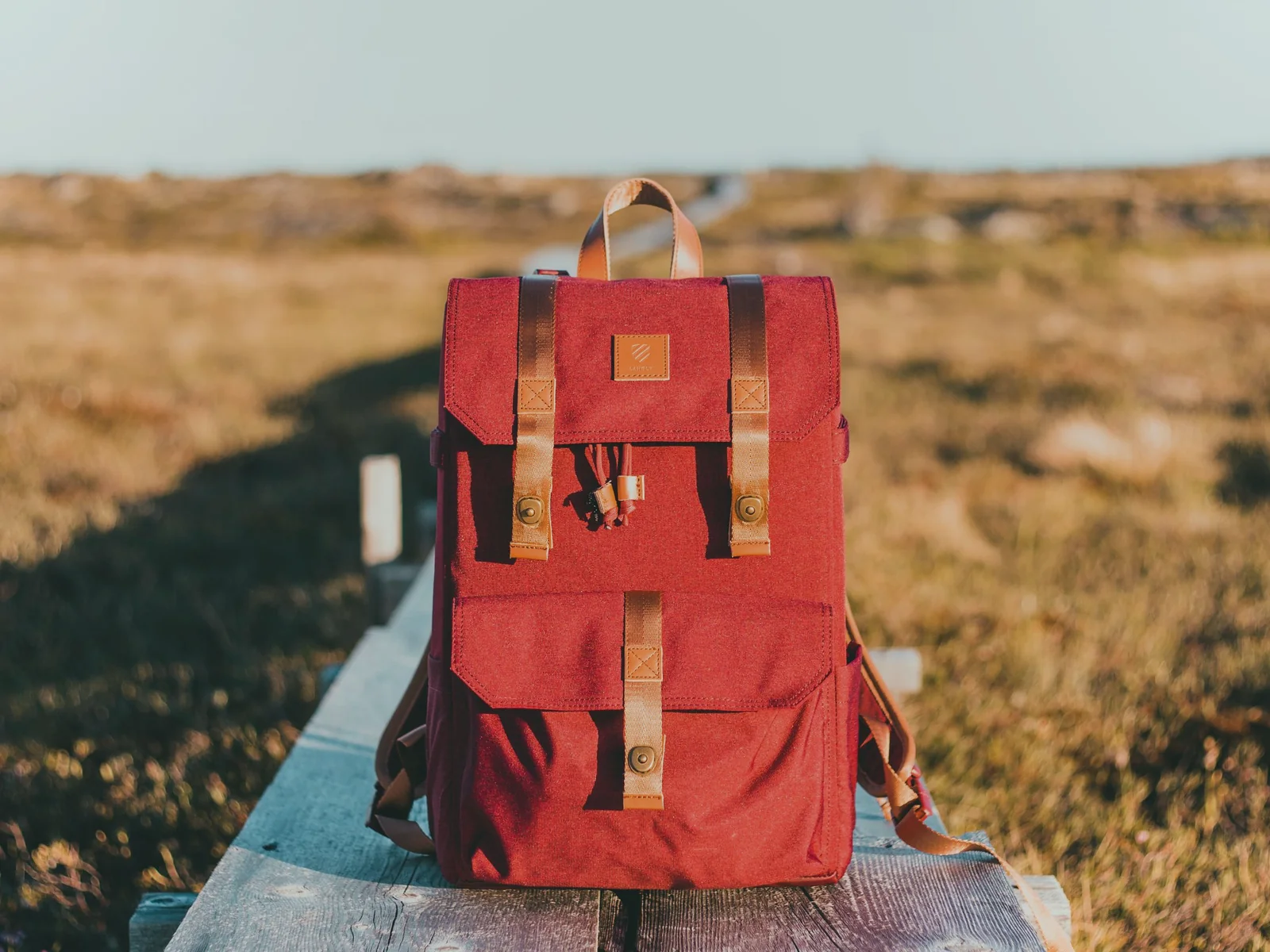 Red backpack resting outdoors in bright sunlight
